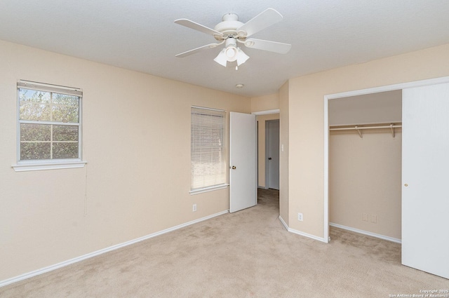 unfurnished bedroom featuring a closet, baseboards, ceiling fan, and carpet