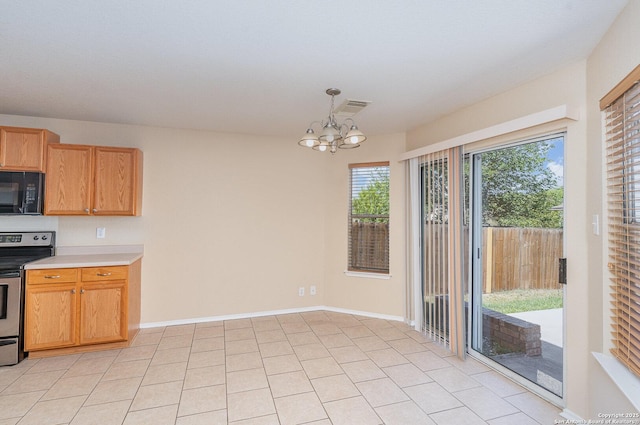 kitchen with an inviting chandelier, black microwave, light countertops, stainless steel range with electric stovetop, and visible vents