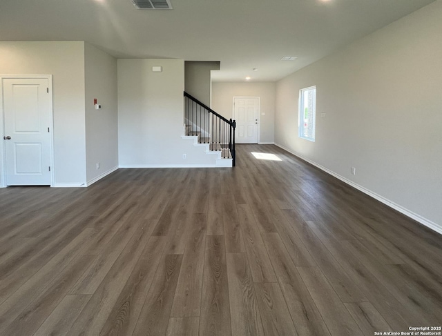 13750 Birch Xing, San Antonio, TX 78252 - unfurnished room featuring dark wood-type flooring, baseboards, visible vents, and stairs
