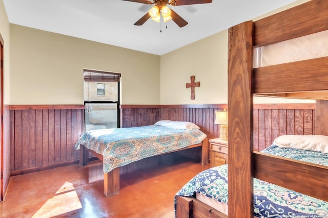 723 Tierra Linda, Concan, TX 78838 - bedroom featuring wood walls, a ceiling fan, and wainscoting