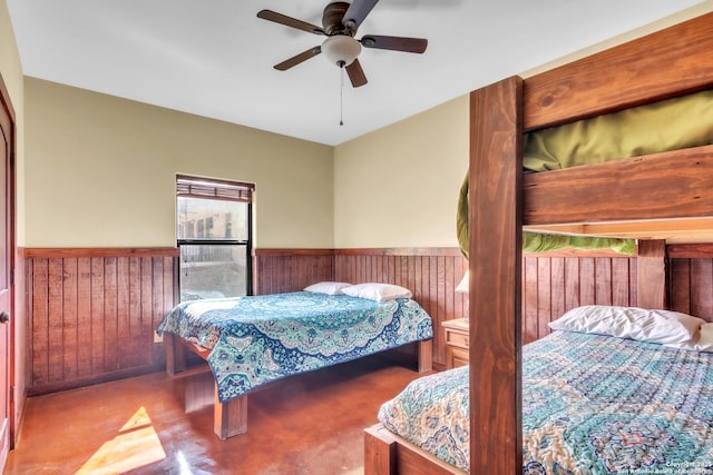 723 Tierra Linda, Concan, TX 78838 - bedroom featuring wood walls, a ceiling fan, and wainscoting