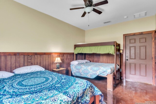 723 Tierra Linda, Concan, TX 78838 - bedroom featuring finished concrete floors, visible vents, ceiling fan, and wainscoting