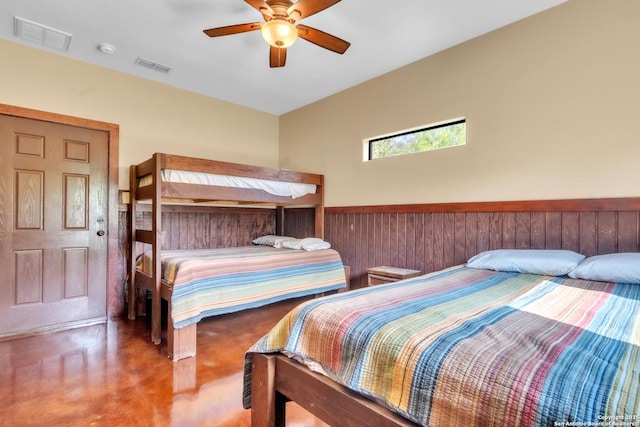 723 Tierra Linda, Concan, TX 78838 - bedroom featuring wainscoting, finished concrete floors, visible vents, and ceiling fan