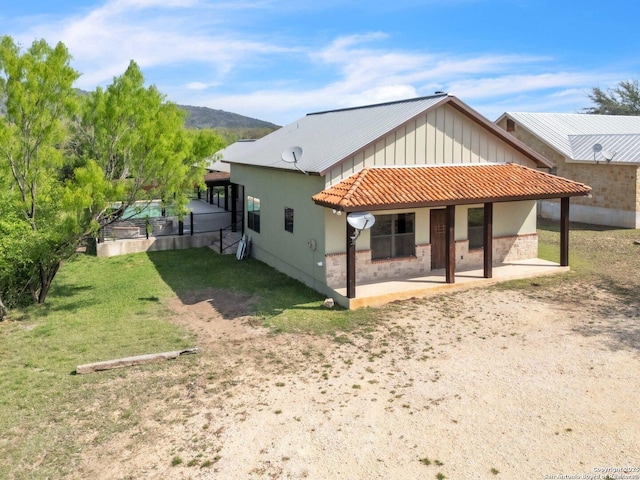 723 Tierra Linda, Concan, TX 78838 - back of property with board and batten siding, a patio area, and a lawn
