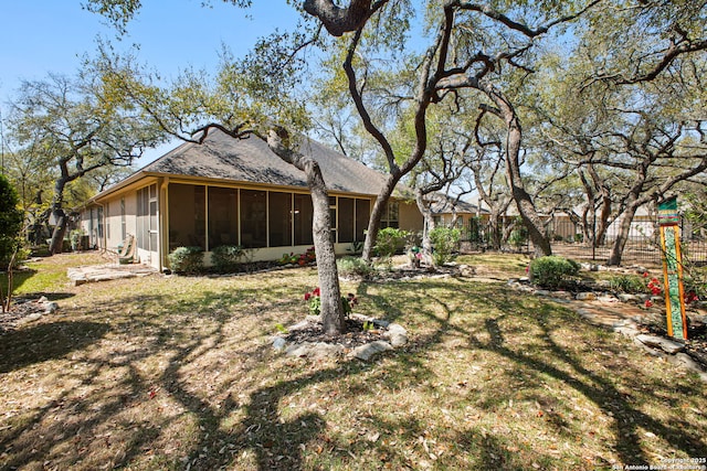 view of yard with a sunroom and fence