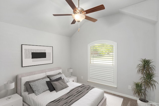 carpeted bedroom featuring a ceiling fan and vaulted ceiling