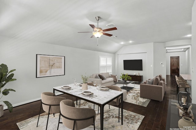 living area featuring baseboards, vaulted ceiling, dark wood-style floors, a ceiling fan, and visible vents