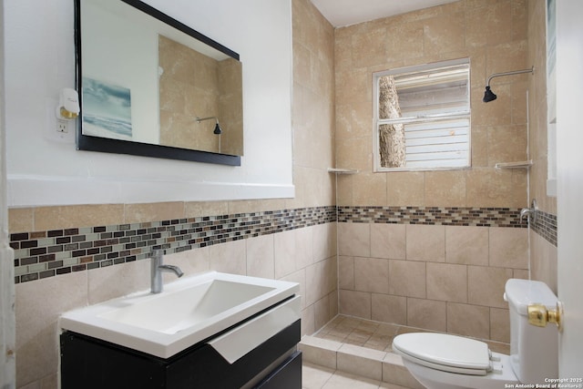 full bathroom with a shower stall, tile walls, vanity, and toilet