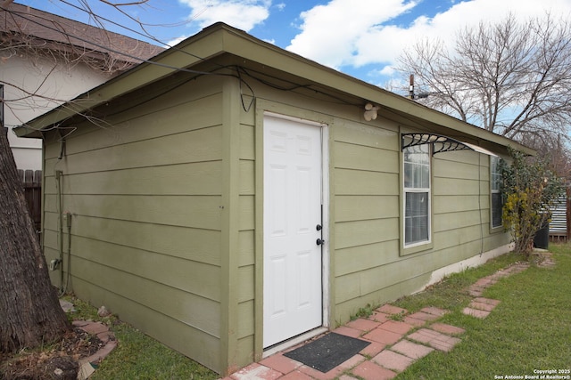 view of outdoor structure featuring fence and an outbuilding