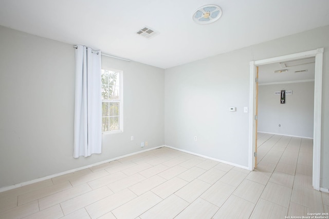 unfurnished room featuring baseboards and visible vents