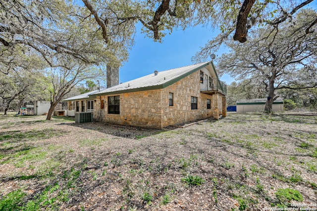 21440 Fm 306, Canyon Lake, TX 78133 - back of house with metal roof, a balcony, stone siding, and cooling unit