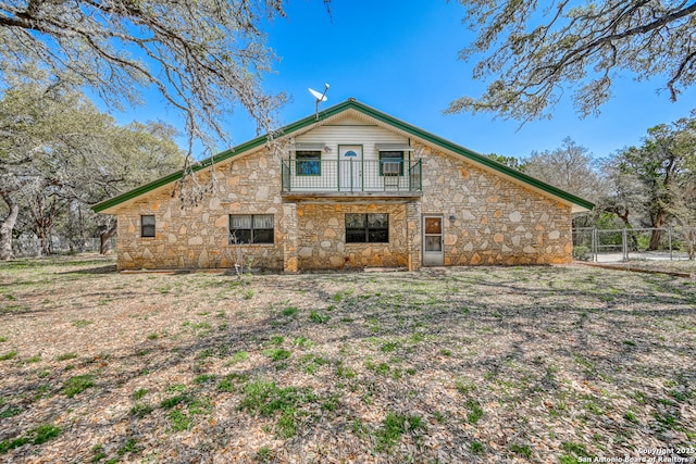 21440 Fm 306, Canyon Lake, TX 78133 - back of property with fence, a gate, stone siding, and a balcony