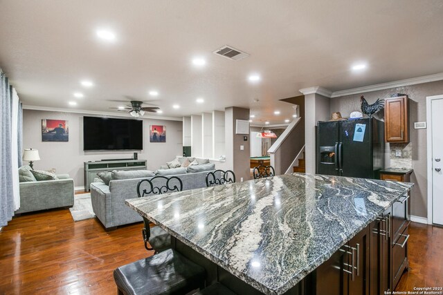 2230 Bedford Stage, San Antonio, TX 78213 - kitchen with visible vents, a kitchen breakfast bar, black fridge, and crown molding