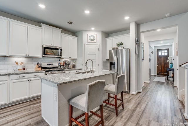 9737 Novacek, San Antonio, TX 78254 - kitchen featuring tasteful backsplash, visible vents, a sink, light wood-style floors, and stainless steel appliances