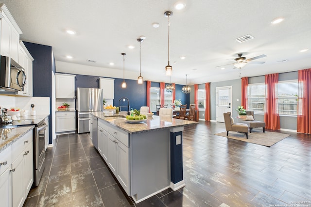 2700 La Mundial, Seguin, TX 78155 - kitchen featuring ceiling fan, a sink, stainless steel appliances, open floor plan, and a center island with sink