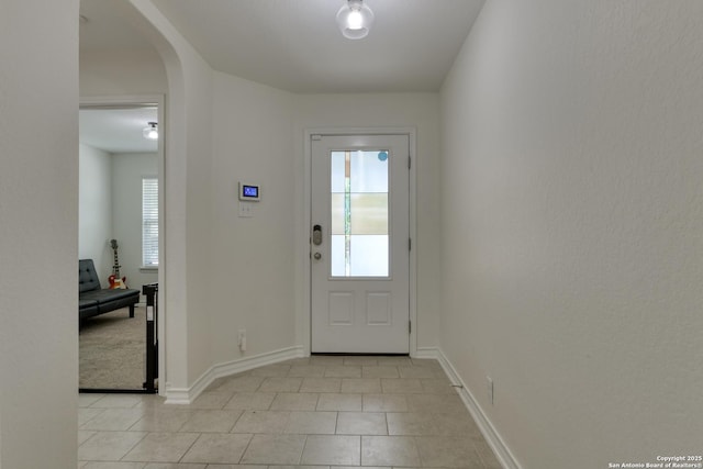 8732 Ironwood Hl, San Antonio, TX 78254 - doorway to outside with arched walkways, baseboards, and light tile patterned flooring