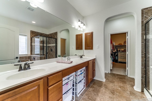 full bath featuring a sink, a stall shower, and visible vents
