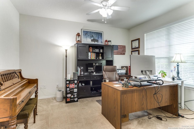 home office with baseboards, ceiling fan, and light carpet