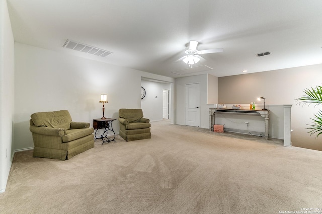 sitting room featuring visible vents, carpet flooring, and a ceiling fan