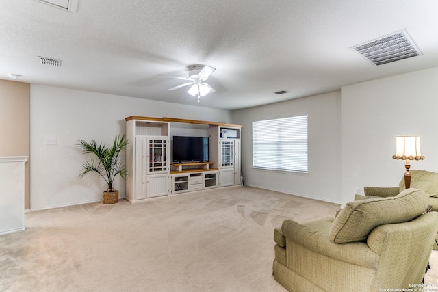 living room with light colored carpet, a ceiling fan, visible vents, and baseboards