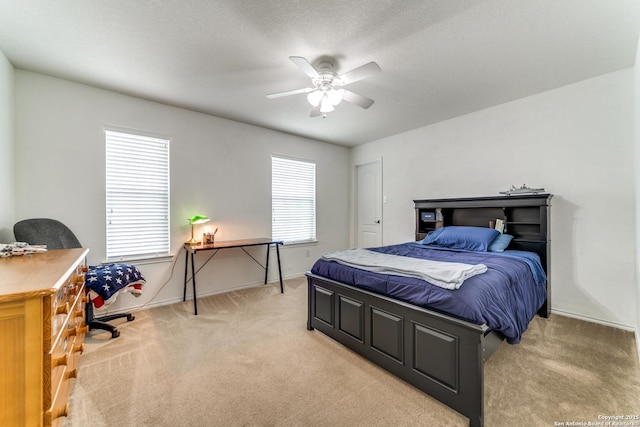 bedroom with a ceiling fan, baseboards, and light carpet