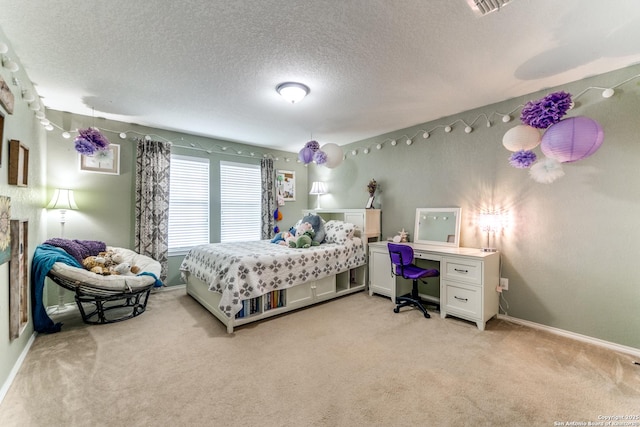 bedroom with baseboards, a textured ceiling, visible vents, and light carpet