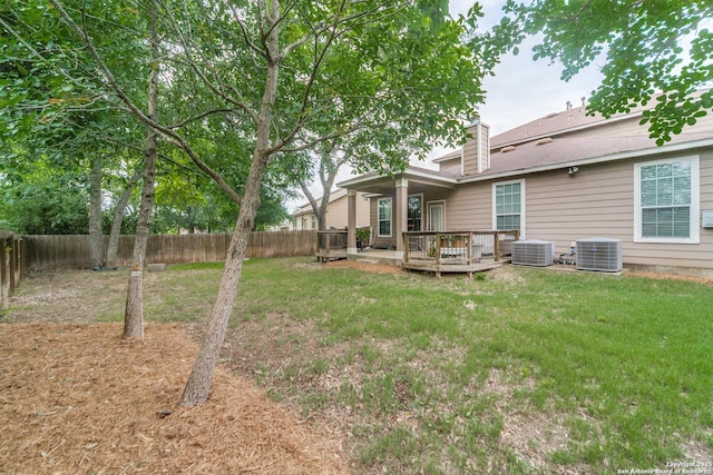 rear view of property with a yard, central AC unit, and a fenced backyard