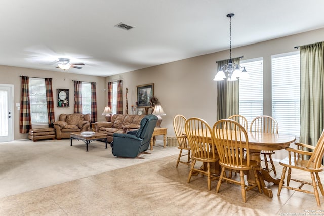 dining room featuring visible vents, light carpet, and ceiling fan with notable chandelier