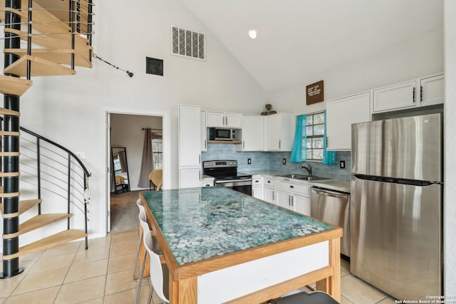 208 Woodridge, Canyon Lake, TX 78133 - kitchen with high vaulted ceiling, a sink, stainless steel appliances, white cabinets, and visible vents