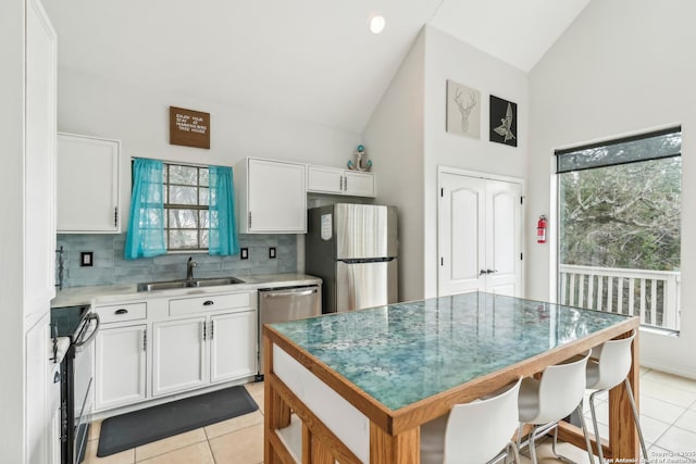 208 Woodridge, Canyon Lake, TX 78133 - kitchen featuring high vaulted ceiling, white cabinetry, stainless steel appliances, and a sink
