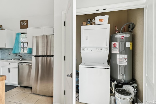 208 Woodridge, Canyon Lake, TX 78133 - laundry room featuring stacked washer / dryer, laundry area, a sink, light tile patterned flooring, and electric water heater
