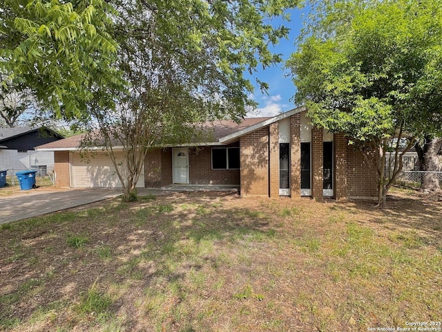 view of front of property with a garage, fence, a front lawn, brick siding, and driveway