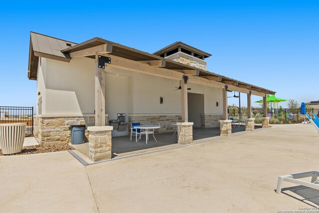 7622 Jacksboro Dr, San Antonio, TX 78252 - back of house with a ceiling fan, stone siding, fence, a patio, and stucco siding