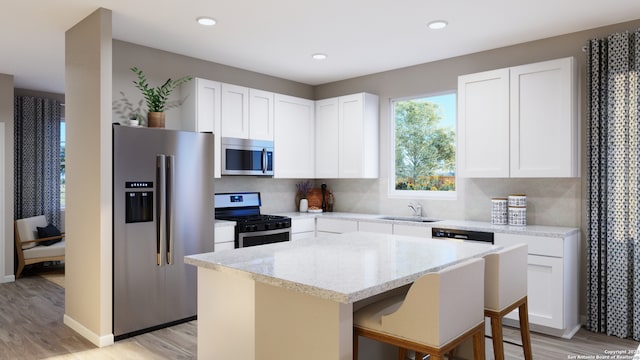7622 Jacksboro Dr, San Antonio, TX 78252 - kitchen with light wood-style flooring, a center island, appliances with stainless steel finishes, and a sink