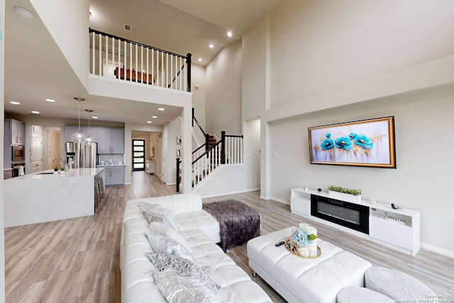 13324 Romulus Way, San Antonio, TX 78245 - living room with stairs, light wood-type flooring, a high ceiling, recessed lighting, and baseboards