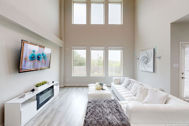 13324 Romulus Way, San Antonio, TX 78245 - living room with a high ceiling, light wood-style flooring, and baseboards