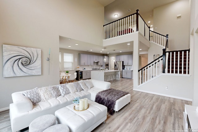 13324 Romulus Way, San Antonio, TX 78245 - living room featuring light wood-style floors, a high ceiling, stairway, and baseboards