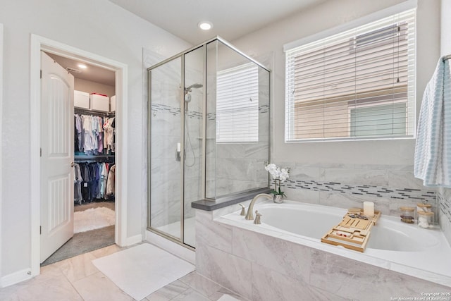 13324 Romulus Way, San Antonio, TX 78245 - bathroom featuring a shower stall, a garden tub, a walk in closet, recessed lighting, and baseboards