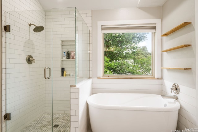 bathroom with a freestanding tub and a shower stall