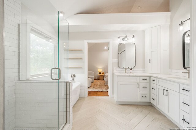 ensuite bathroom featuring a shower stall, a soaking tub, vanity, and ensuite bathroom