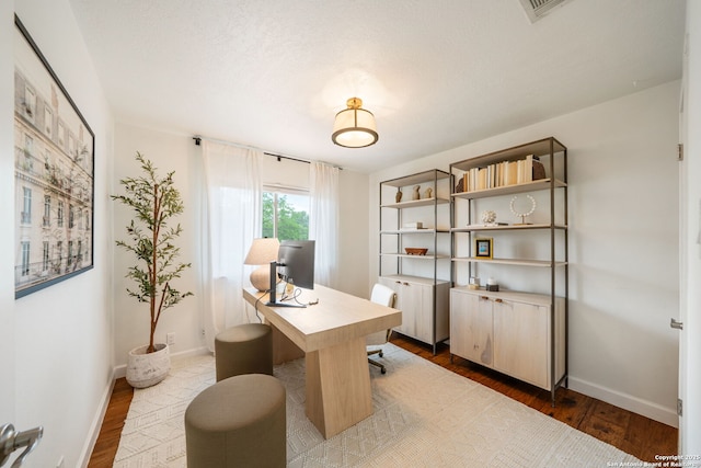 office with wood finished floors, visible vents, and baseboards