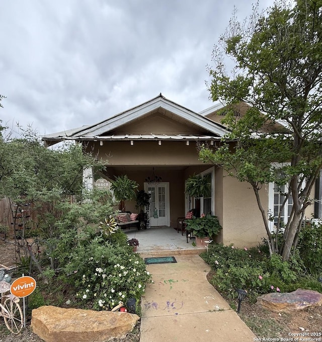 view of exterior entry featuring french doors, a patio area, and stucco siding