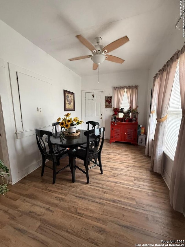 dining area with baseboards, a ceiling fan, and wood finished floors