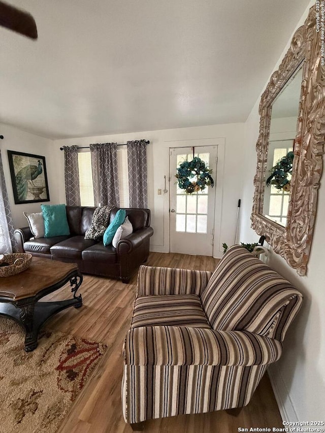 living area with plenty of natural light and wood finished floors