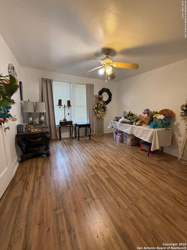 interior space featuring wood finished floors, ceiling fan, and baseboards