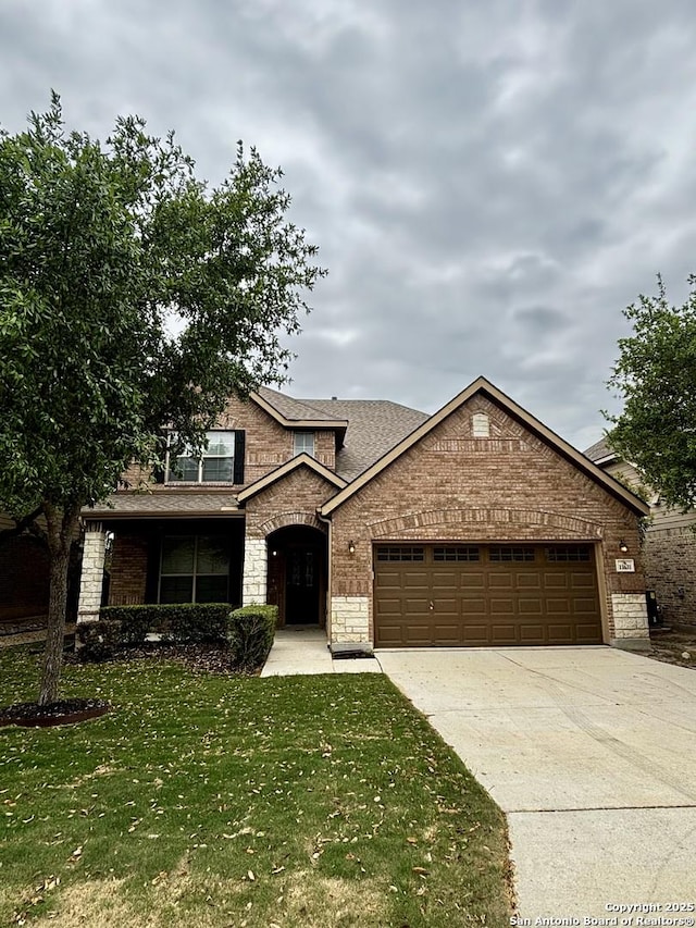 11631 Sangria, San Antonio, TX 78253 - view of front facade with a front yard, stone siding, an attached garage, a shingled roof, and concrete driveway