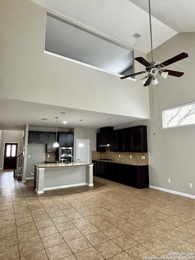 11631 Sangria, San Antonio, TX 78253 - kitchen featuring dark cabinets, tasteful backsplash, visible vents, ceiling fan, and high vaulted ceiling