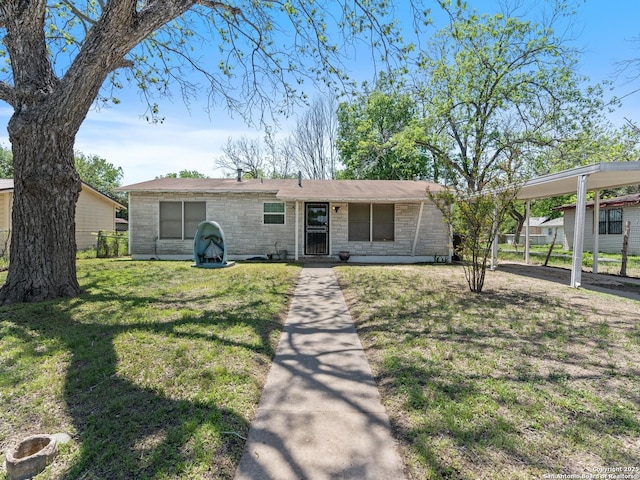 view of front of home featuring a carport, a front lawn, and fence