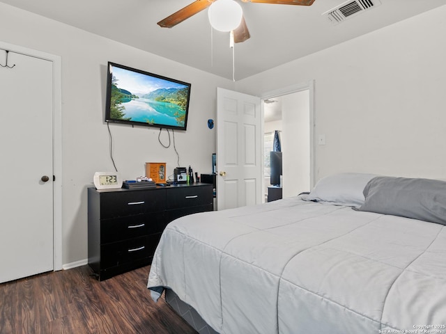 bedroom featuring dark wood-style flooring, a ceiling fan, and visible vents