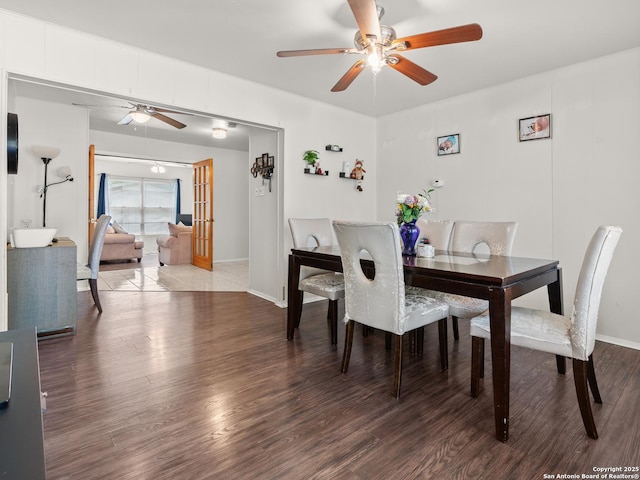 dining room featuring wood finished floors, baseboards, and a ceiling fan